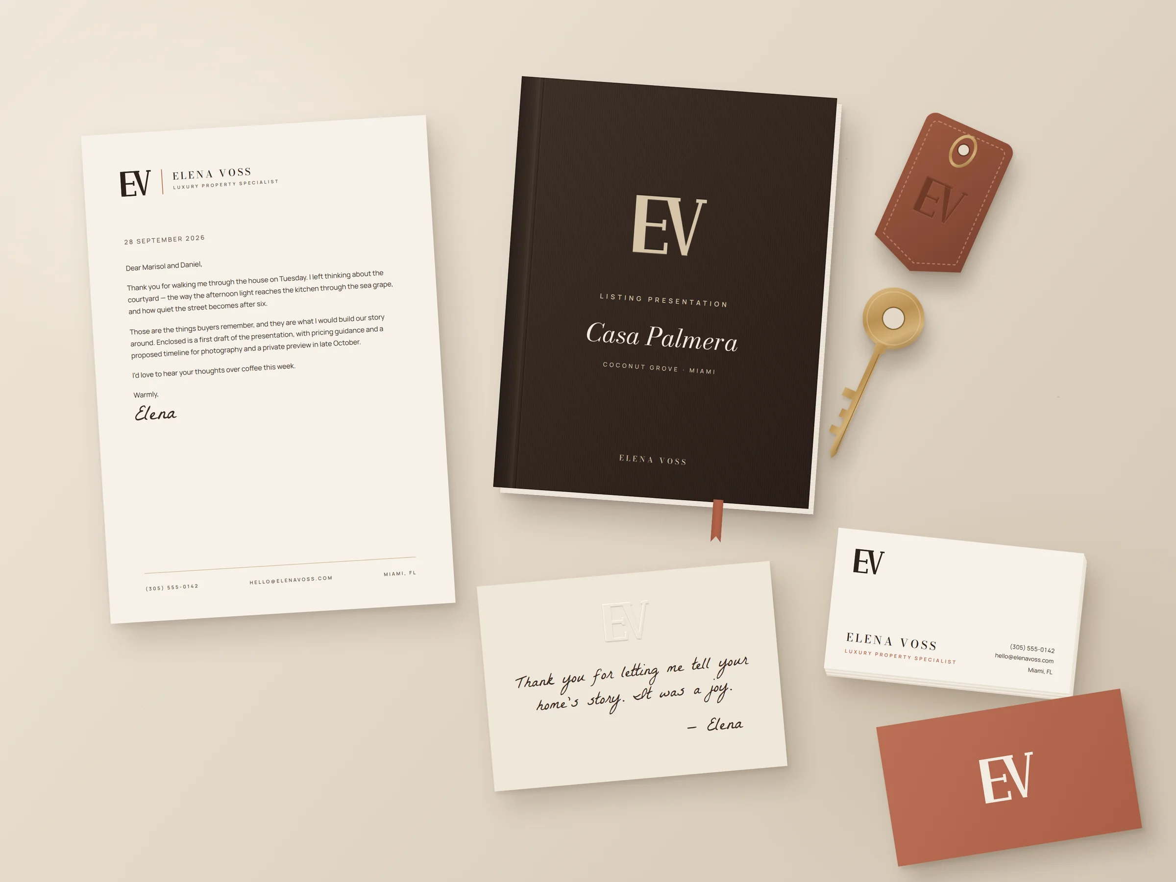 Elena Voss stationery: letterhead, espresso listing presentation book, terracotta and bone business cards, embossed thank-you card and brass key.